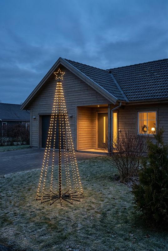 Geometrischer LED-Tannenbaum mit Stern als leuchtender Blickfang im Garten