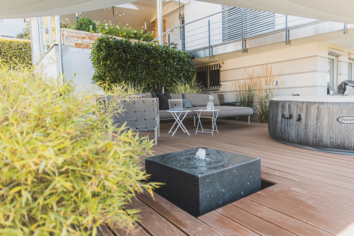 Terrasse mit dunklen Dielen Wasserspiel Möbeln und Wirlpool