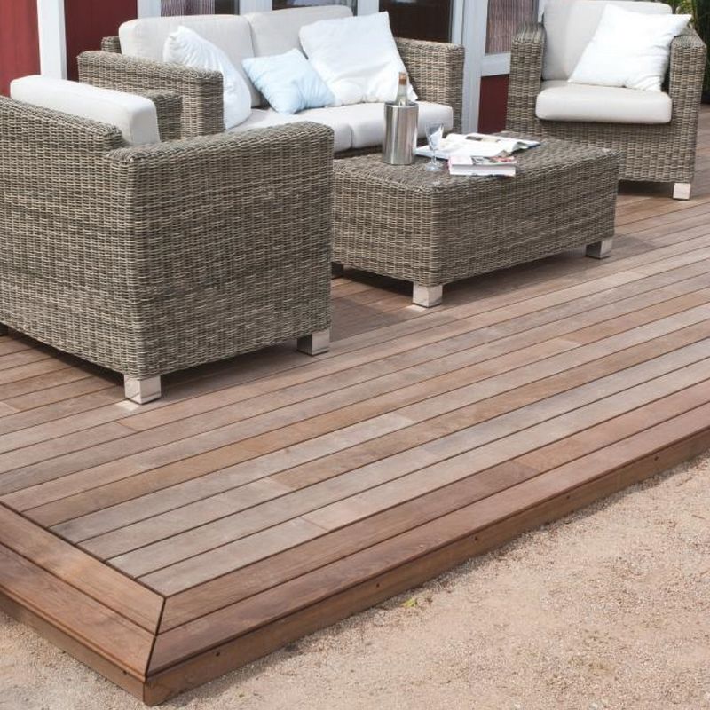 Holzterrasse mit Loungemöbeln aus Geflecht