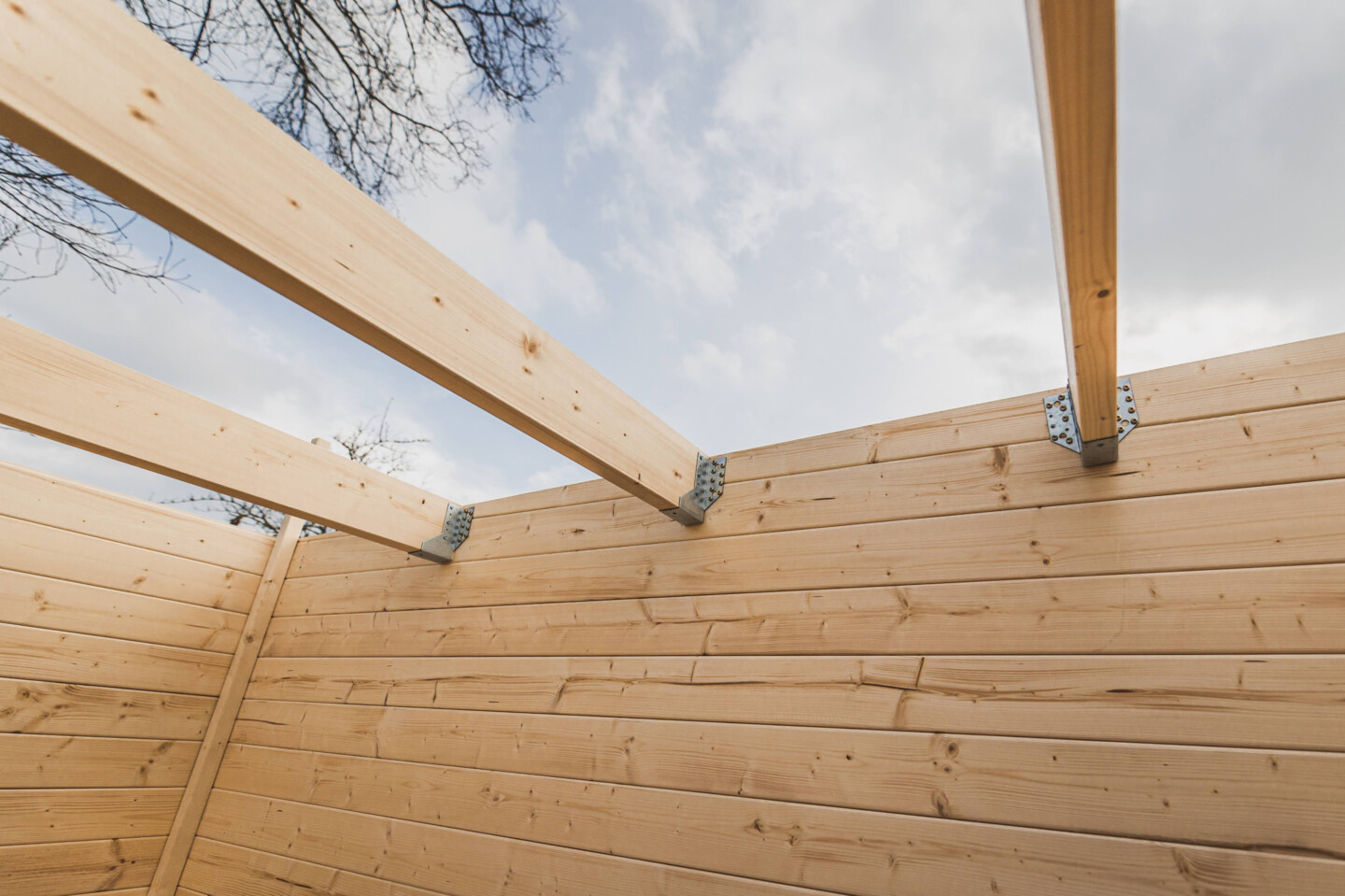 Befestigt werden die Sparren mit Balkenschuhen an der Innenseite der Seitenwände