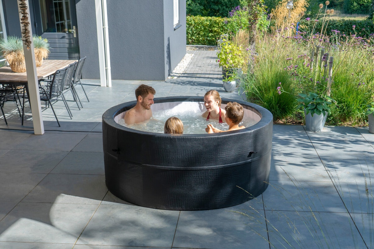 Exit Leather Premium Whirlpool für 4 Personen Vier Personen sitzen in einem aufblasbaren Whirlpool auf einer Terrasse