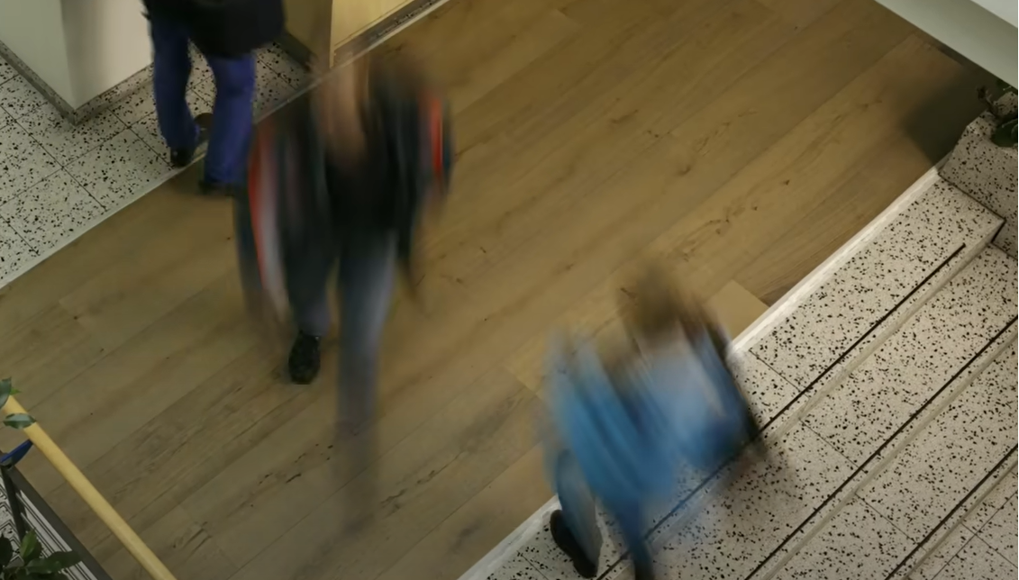 Harte Test-Bedingungen für Lindura-Böden Menschen laufen über einen Holzboden in einem Treppenhaus